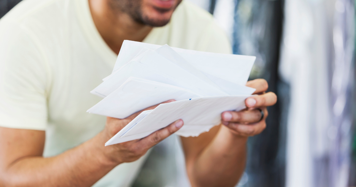 a man holding letters he received through a direct mailing list