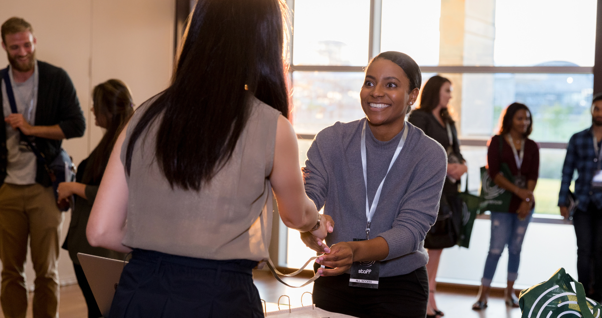 Two women shaking hands at a work conference