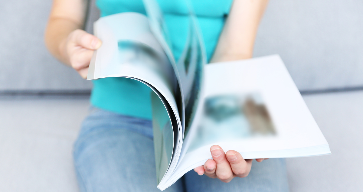 A woman flips through a magazine, an example of print media