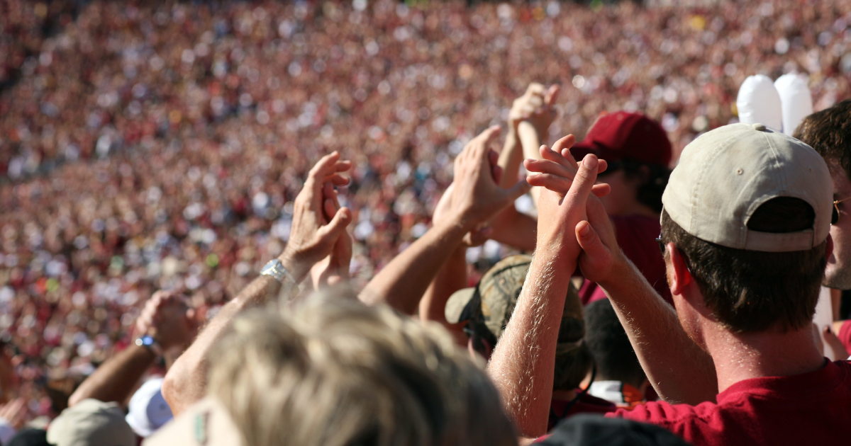 Fans clapping their hands at a sporting event.